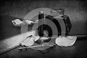 Vintage old romantic still life image of writing paraphrenalia including fountain pen ink bottle and journal book