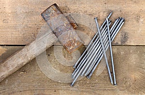 Vintage old rusty hammer and nails lying on wooden boards. Top view