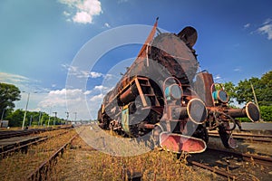 Vintage old rusty steam train under blue sky