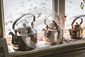 Vintage old style metal kettle on the window sill
