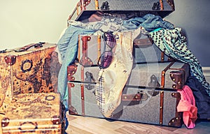 Vintage old suitcases crammed with clothes and sunglasses.