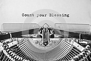 Vintage old typewriter on white background with text Count your Blessing.
