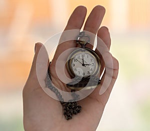 Vintage old watch on a chain. hand holding a watch on a chain.