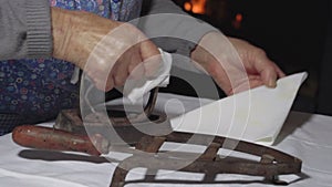 Vintage old woman ironing hankies lateral slow motion MF