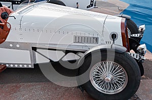 vintage open-top car at the yacht show in Monaco on a sunny day, leather seats, spoked wheels, close-up