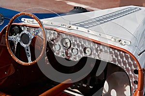 vintage open-top car at the yacht show in Monaco on a sunny day, leather seats, spoked wheels, close-up