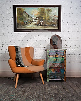 Vintage orange armchair, colorful cupboard, old radio and hanged painting