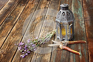 Vintage oriental lamp, sage plant and garden scissors on wooden table. still life concept. fine art.