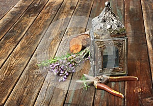 Vintage oriental lamp, sage and rosemary on wooden table. still life concept. fine art.