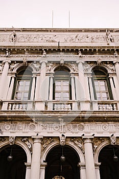 Vintage ornate windows and columns, venetian style, on fragment of building`s luxurious building in Venice. Traditional
