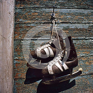 Vintage pair of mens ice skates hanging on a wall