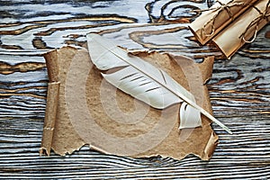 Vintage paper rolls parchment quill on wooden board