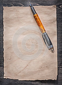 Vintage paper sheet fountain pen on wooden board top view