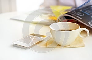 Vintage and pastel color tone style of coffee cup with mobile phone and businessman in coffee shop