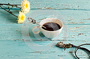 Vintage pastel color tone style of coffee cup and stainless spoon on blue wooden