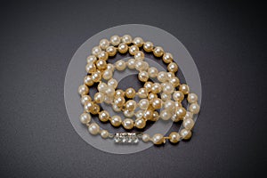 Vintage pearl necklace with diamond studded pendant On a stone background