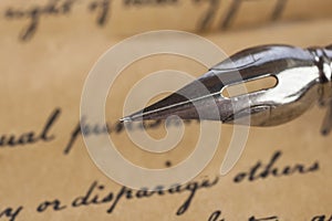 A vintage pen on a handwritten paper