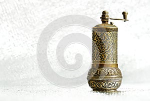 Vintage pepper mill on silver background. Spice grinder. Sample for traditional packing of pepper seed. Close-up