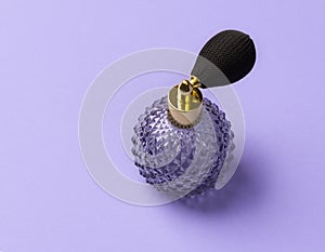 Vintage perfume spray bottle on purple background