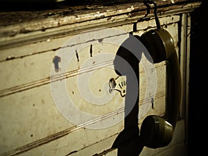 Vintage phone hangs on grunge dirty vintage cabinet drawers