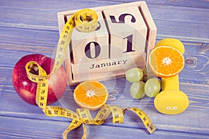 Vintage photo, 1 January on cube calendar, fruits, dumbbells and tape measure, new years resolutions