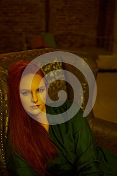 Vintage photo of Beautiful red haired young woman posing in old loft apartment in Tbilisi