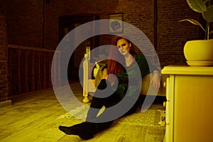 Vintage photo of Beautiful red haired young woman posing in old loft apartment in Tbilisi