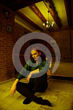 Vintage photo of Beautiful red haired young woman posing in old loft apartment in Tbilisi