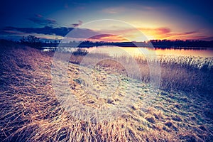 Vintage photo of beautiful sunset over calm lake