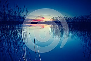 Vintage photo of beautiful sunset over calm lake