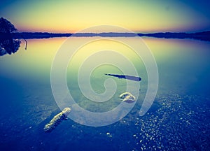 Vintage photo of beautiful sunset over calm lake