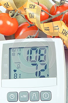 Vintage photo, Blood pressure monitor with result of measurement, fruits with vegetables and centimeter, healthy lifestyle