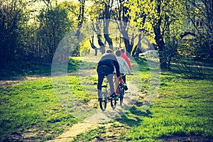 Vintage photo of boys riding on bikes in park