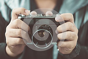 Vintage photo camera in the hands of man, soft focus.