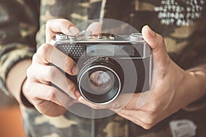 Vintage photo camera in the hands of man, soft focus.