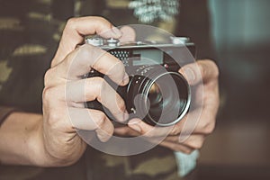 Vintage photo camera in the hands of man, soft focus.