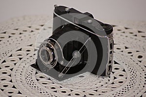 Vintage photo camera on a lace tablecloth