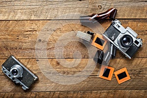 vintage photo camera, negatives and slides on a textured wooden table. View from above. retro style. Space for text