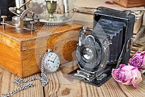 Vintage photo camera, pocket watches and dried roses