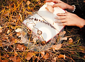 Vintage photo of a collection of poetry that keeps a girl lying in the autumn grass