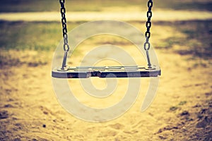 Vintage photo of empty swing on children playground