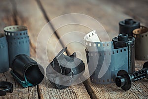 Vintage photo film rolls and cassette on old desk.