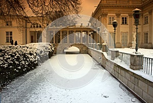 Vintage photo of a fragment of the palace on the water in Lazienki Royal Park in winter