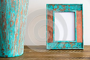 Vintage photo frame on wooden table over white wall background