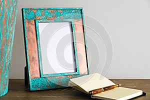 Vintage photo frame on wooden table over white wall background