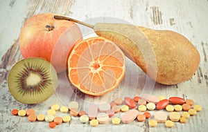 Vintage photo, Fresh fruits and colorful medical pills, choice between healthy nutrition and medical supplements