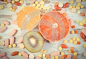 Vintage photo, Fresh fruits and colorful medical pills, choice between healthy nutrition and medical supplements