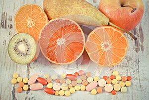 Vintage photo, Fresh fruits and colorful medical pills, choice between healthy nutrition and medical supplements