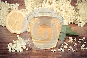 Vintage photo, Fresh healthy juice, elderberry flowers and lemon on rustic board