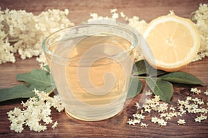 Vintage photo, Fresh healthy juice, elderberry flowers and lemon on rustic board